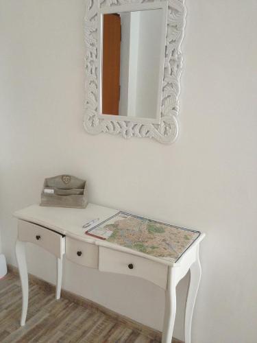 a white dressing table with a mirror on a wall at St Peter Lodge in Rome