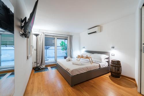 um quarto com uma cama e uma grande janela em LuxAvocadoLoft DUOMO 10m em Milão