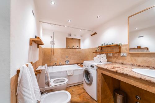 a bathroom with a toilet a sink and a washing machine at LuxAvocadoLoft DUOMO 10m in Milan