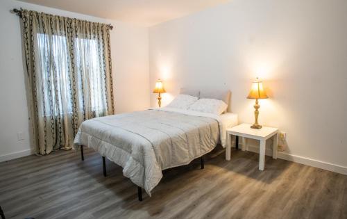 a bedroom with a bed and a table and two lamps at Nature's Retreat in Latchford