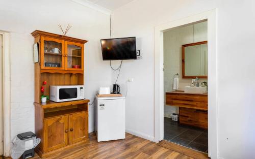 a kitchen with a refrigerator and a tv on the wall at BIG4 Cape Jervis Accommodation & Caravan Park in Cape Jervis