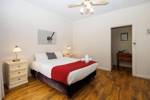 a bedroom with a bed with a red and white blanket at BIG4 Cape Jervis Accommodation & Caravan Park in Cape Jervis