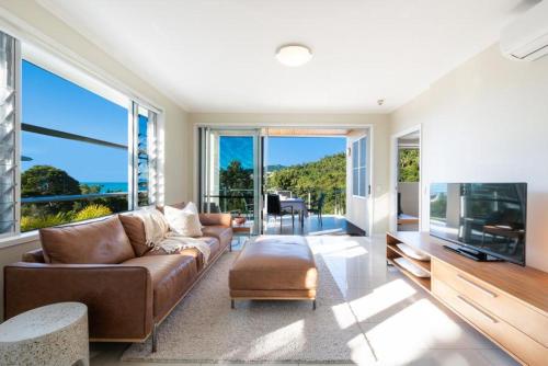 a living room with a couch and a flat screen tv at 30 Airlie Beach Bliss at The Summit in Airlie Beach