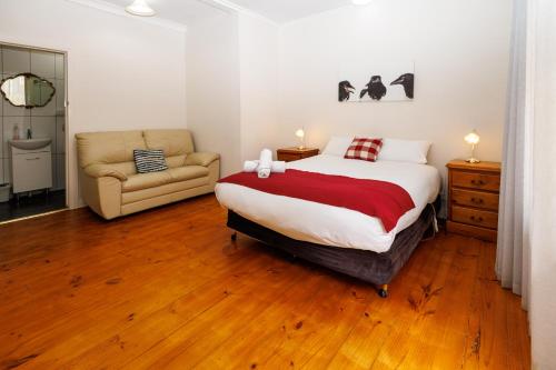 a bedroom with a bed and a couch and a chair at BIG4 Cape Jervis Accommodation & Caravan Park in Cape Jervis