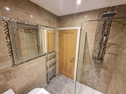 a bathroom with a shower and a glass door at Shirley's Place in Boston Spa