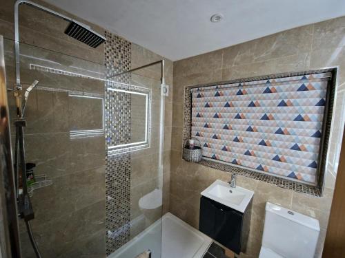a bathroom with a shower and a toilet and a sink at Shirley's Place in Boston Spa