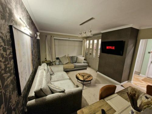 a living room with a couch and a tv at Shirley's Place in Boston Spa