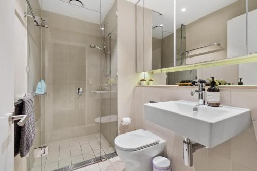 a bathroom with a sink and a toilet and a shower at Melbourne Docklands Riverside Views in Melbourne