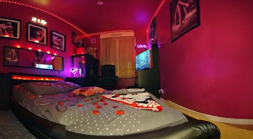 una camera da letto con un letto con luci viola di Love Room Amour Glamour Lib proche gare rer 5 minute à pied ad Aulnay-sous-Bois