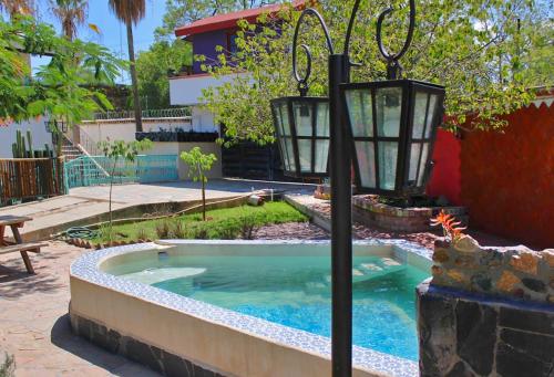een klein zwembad met een lantaarn in een tuin bij Casa Hala LOFT & SPA LUXURY in León