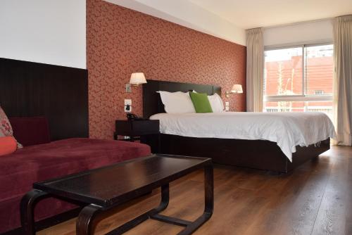 een hotelkamer met een bed en een salontafel bij Hotel BA Abasto in Buenos Aires