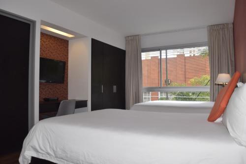 una camera con un letto bianco e una finestra di Hotel BA Abasto a Buenos Aires