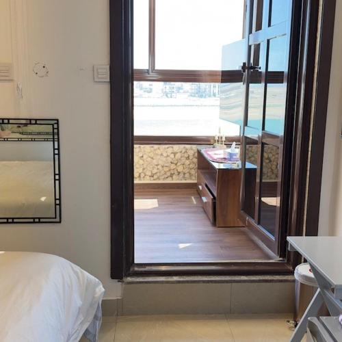 a bedroom with a large window and a sink at منتجع اووه يامال البحري في الخيران OOh Yaa Mal in Al Khīrān
