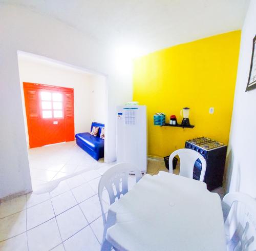 a dining room with a white table and a refrigerator at FLAT DA DANI Galinhos RN in Galinhos