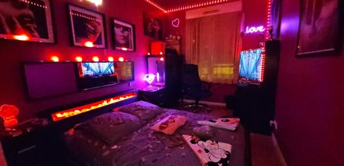 a room with a bed in a room with red lights at Love Room Chambre Privée Chez Habitant proche gare rer 5 minute à pied in Aulnay-sous-Bois
