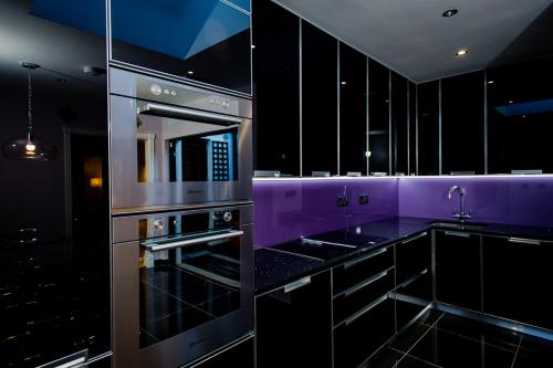 a purple kitchen with a stove top oven at Luxury Townhouse in Dublin