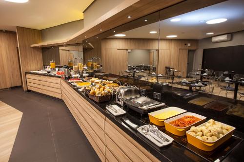 a buffet line in a restaurant with food on it at Momax Hotel in Marília