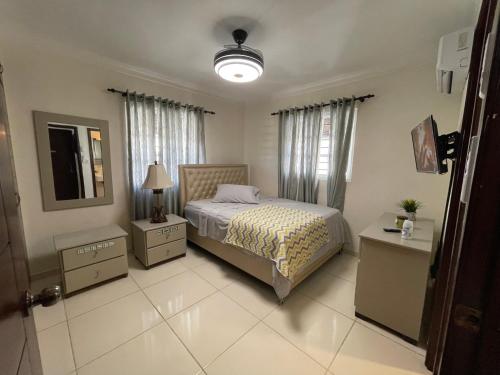 a bedroom with a bed and two tables and a mirror at Apartamento de 2 Habitaciones con Seguridad y Cámaras in Mendoza
