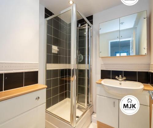 y baño con ducha, lavabo y espejo. en The Westbourne Short-Stay, en Ince-in-Makerfield