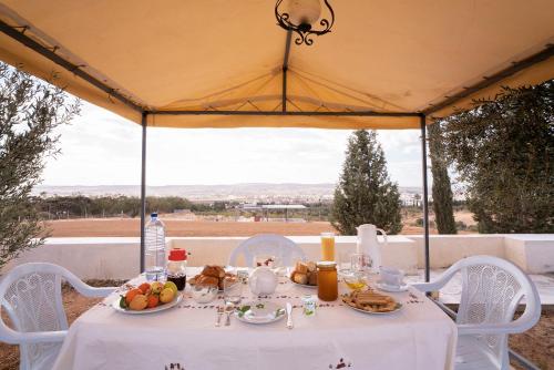 einen Tisch mit einem weißen Tischtuch und Essen drauf in der Unterkunft Cozy Home Stay 