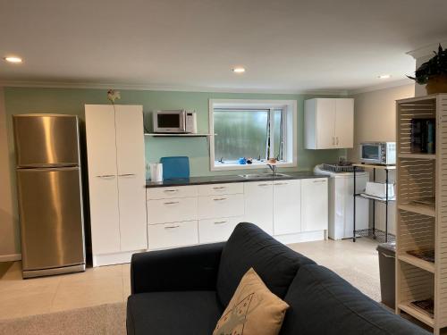 a living room with a couch and a kitchen at Churchill Oasis by the sea in Tauranga