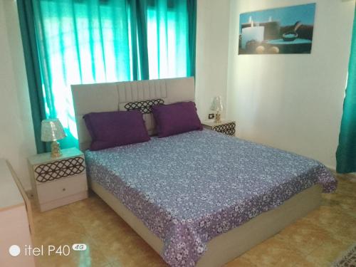 a bedroom with a large bed with purple pillows at Yaso Roof & Apartments in Amman