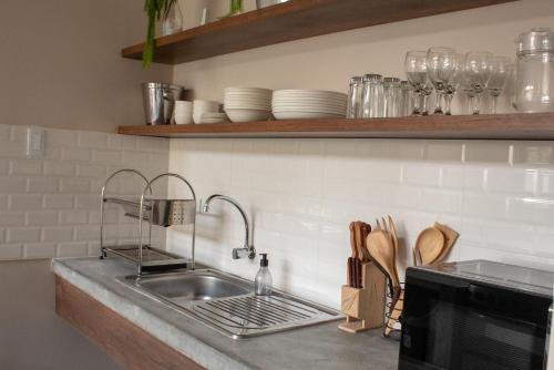 a kitchen counter with a sink and some plates at Hermosa casa de campo con piscina en Cieneguilla in Cieneguilla