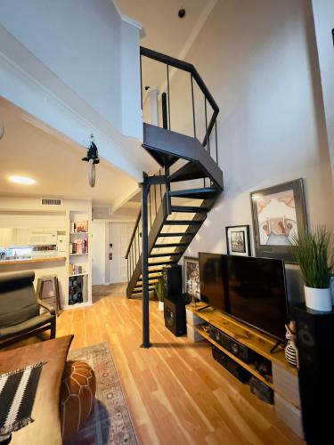 a living room with a spiral staircase in a house at HiFi Sound & Comfort - Uptown Dallas / 2-story loft in Dallas