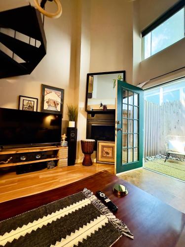 a living room with a television and a living room with a fireplace at HiFi Sound & Comfort - Uptown Dallas / 2-story loft in Dallas