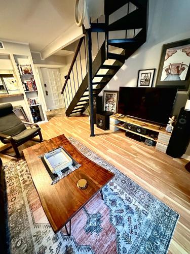 a living room with a coffee table and a staircase at HiFi Sound & Comfort - Uptown Dallas / 2-story loft in Dallas