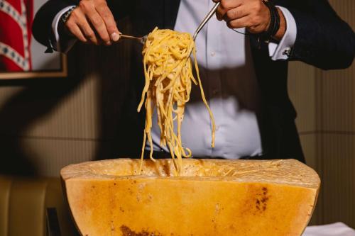 a man is eating spaghetti from a bowl at art'otel London Battersea Power Station, Powered by Radisson Hotels in London