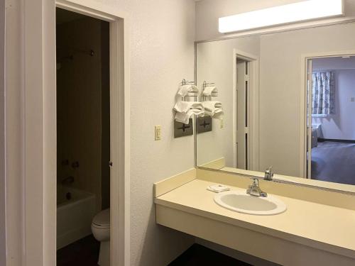 un baño con lavabo y espejo en Motel 6 Sandersville, GA, en Sandersville