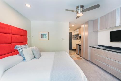 テルライドにあるMountainside Inn 419-21 Hotel Roomのベッドルーム(白いベッド、赤いヘッドボード、テレビ付)