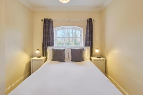 a bedroom with a large white bed with two lamps at Host & Stay - Nunnery Fields in Canterbury