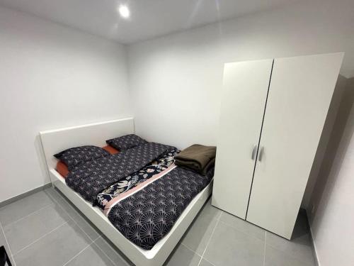una piccola camera con letto e armadio di Le Paisible a Pontcarré