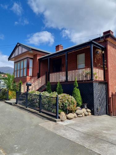 a red brick house with a black fence at Lords Rest Apartment - Private and Central with Free Parking and Great WIFI in Hobart