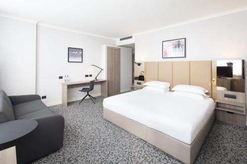 a bedroom with a bed and a desk and a chair at Crowne Plaza Milan Linate by IHG in San Donato Milanese