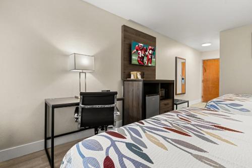 a bedroom with a bed and a desk and a chair at Red Roof Inn Washington, NC in Washington