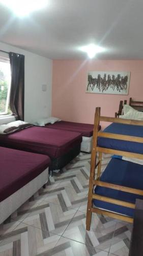 1 dormitorio con 2 camas y ventana en Lindo Sítio, Itapeva MG a 120km, en Itapeva