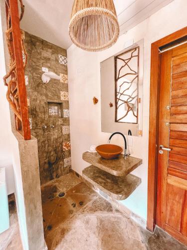 a bathroom with a bowl sink and a shower at Pousada Fortal Preá in Prea