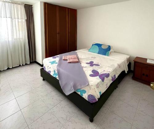 a bedroom with a bed with a comforter on it at Cómodo apartamento en la Villa Olímpica de Pereira in Pereira