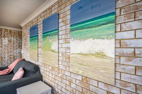 a brick wall with a picture of the ocean at Coast Inn Motel in Ballina