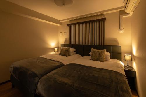 - une chambre dotée d'un grand lit avec des draps et des oreillers blancs dans l'établissement Crest Otemae Stay - Self Check-In Only, à Osaka