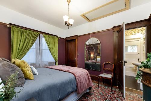 Schlafzimmer mit lila Wänden, einem Bett und einem Fenster in der Unterkunft The Betty - A 1920s Vintage Bungalow in Portland