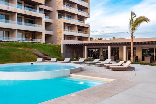 a swimming pool in front of a building at CONDO VISTA AL MAR ZONA TEZAL in Cabo San Lucas