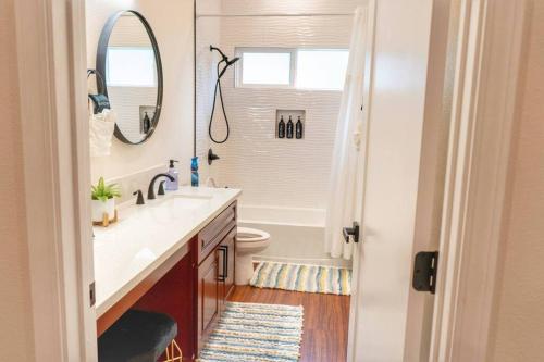 a bathroom with a sink and a toilet and a mirror at Oceanfront Family Retreat - Views, Wi-fi & A/C in Kaaawa