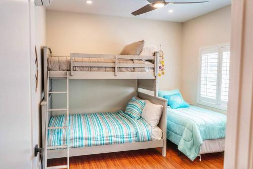 a bunk bed room with two bunk beds and a couch at Oceanfront Family Retreat - Views, Wi-fi & A/C in Kaaawa