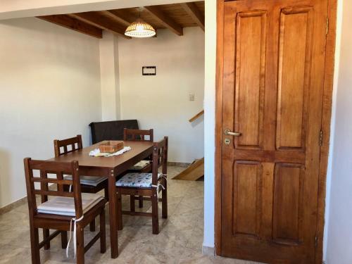 エスケルにあるLa Bonaerense Esquel departamento centricoのダイニングルーム(テーブル、椅子、ドア付)