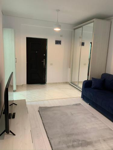 a living room with a blue couch and a black door at Regim Hotelier Heleni in Dudu