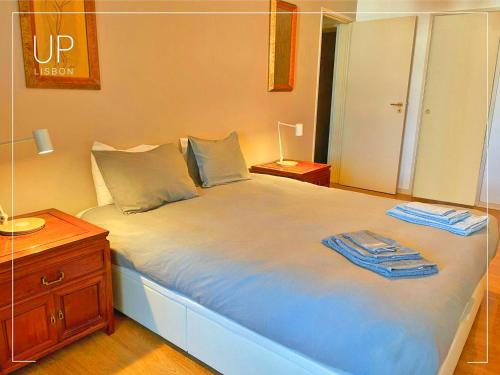 1 dormitorio con 1 cama grande y 2 toallas. en SIX by UP Lisbon I Your home away from home, en Lisboa